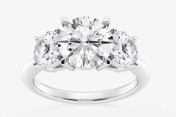 A three-diamond engagement ring with a round center diamond.
