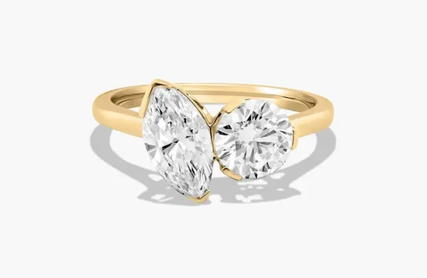 Gold ring with a marquise-cut diamond and a round brilliant-cut diamond.