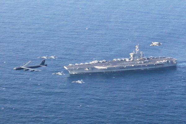Kapal induk USS Abraham Lincoln dan pesawat B-52H Stratofortress Angkatan Udara AS. Foto: Brian M. Wilbur/U.S. Navy via AP