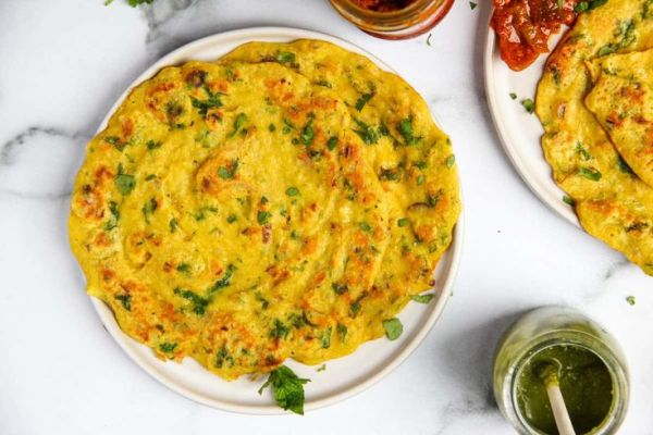 This may contain: an omelet on a plate next to two other plates with sauces and condiments