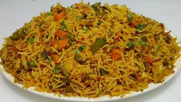 This may contain: a white plate topped with yellow rice and vegetables