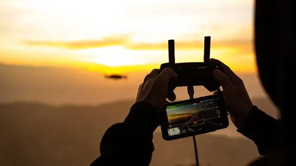 A Man Using Remote To Fly A Drone