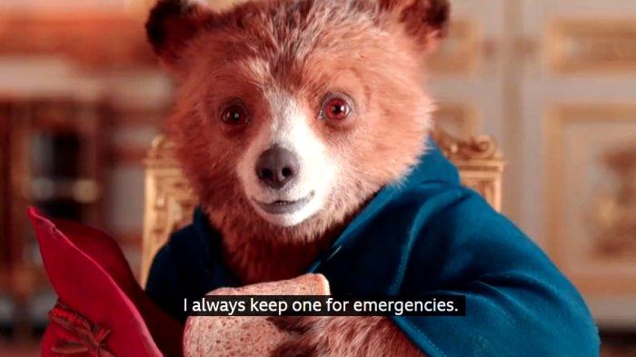 Paddington Bear terlihat menawarkan sandwich marmalade untuk Ratu Elizabeth II