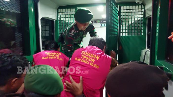 DIGIRNG PETUGAS -- Mantan Bupati Bangka Selatan, Justiar Noer dan mantan Camat Lepar, Dodi Kusumah ketika digiring menuju mobil tahanan Kejaksaan Negeri Bangka Selatan, Kamis (11/12/2025) malam. Keduanya resmi ditetapkan sebagai tersangka atas dugaan tindak pidana korupsi dengan kerugian mencapai Rp45,964 miliar.
