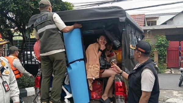 Proses pemindahan warga korban banjir dari aula kantor Kelurahan Bidara Cina ke GOR Otista menggunakan mobil dinas Satpol PP, Jakarta Timur, Jumat (30/1/2026).