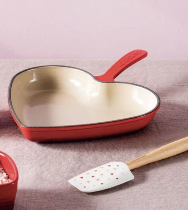 This may contain: a heart shaped pan and spatula on a table