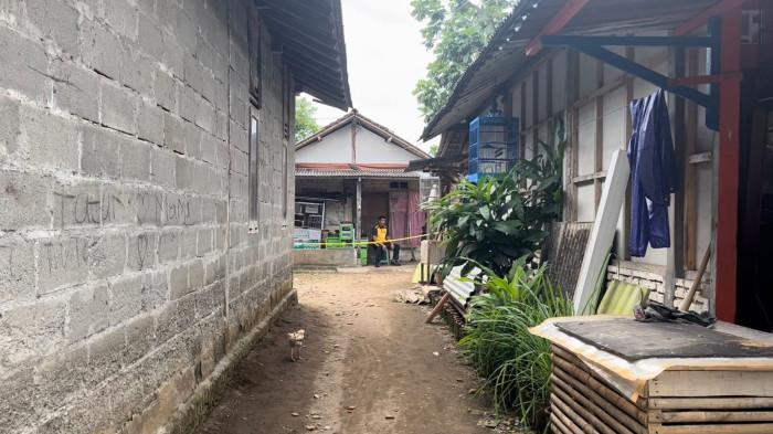 JAGA TKP - Petugas kepolisian berjaga di rumah kontrakan di Kecamatan Cilacap Tengah, Kabupaten Cilacap, yang dipasangi garis polisi, Jumat (30/1/2026), lokasi ditemukannya jasad bocah perempuan berusia 4 tahun yang sebelumnya dilaporkan hilang, dengan kondisi terbungkus plastik dan karung di area kamar mandi belakang rumah.