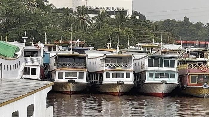 DERMAGA SAMARINDA SEPI - Suasana pelabuhan Sungai Kunjang Samarinda, Kalimantan Timur pada Senin (2/2/2026) siang. Sebanyak 28 kapal masih tambat mati sambil menunggu kepastian SK dari BPH Migas soal Bahan Bakar Minyak subsidi. Dermaga Sungai Kunjang, tak ada aktivitas bongkar muat, warga atau penumpang menunggu dalam cemas, sementara itu para pemilik kapal menanti secarik kertas rekomendasi yang bisa menghidupkan kembali mesin-mesin mereka. 