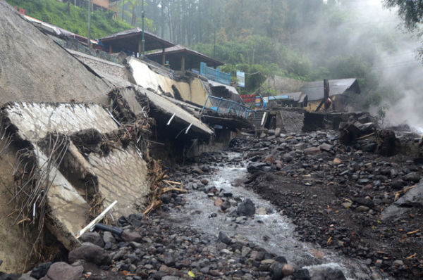 Warga berada samping bangunan yang rusak diterjang banjir bandang di Obyek Wisata Guci, Kabupaten Tegal, Jawa Tengah, Minggu (25/1/2026). Foto: Oky Lukmansyah/ANTARA FOTO