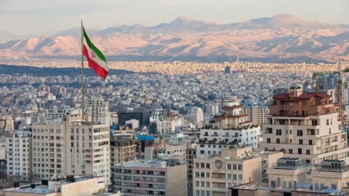 IBU KOTA IRAN - Bendera Iran di ibu kota mereka, Teheran. Iran sempat diguncang gelombang demonstrasi atas krisis multisektor yang terjadi di negara tersebut, mendorong aparat pemerintah melakukan aksi represif yang berujung ancaman Amerika Serikat (AS) untuk turun tangan dengan menyerang pemerintah Iran.