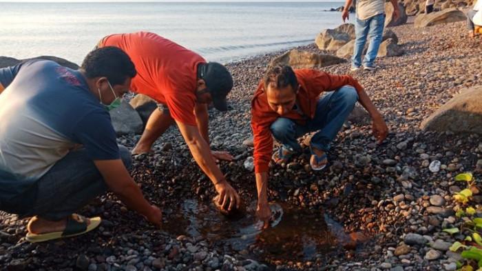 Wisatawan sedang merasakan air panas alami, di bibir pantai Kawaliwu di Kelurahan Riangkotek, Kecamatan Lewo Lema, Flores Timur, Nusa Tenggara Timur, Kamis (11/10/2018).
