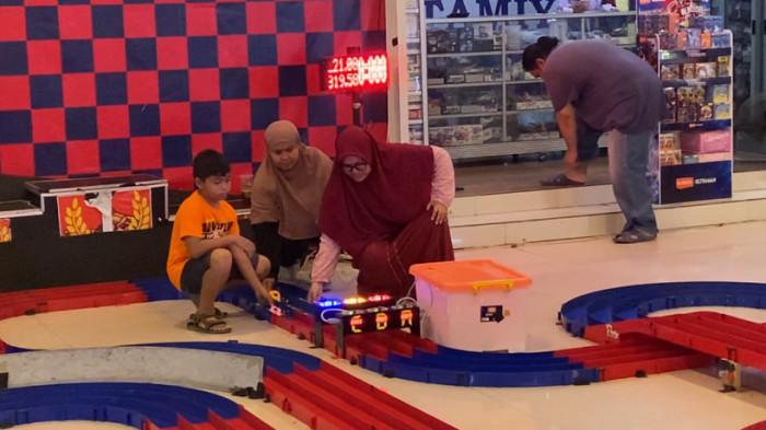 BERSIAP START - Arina Utaming Tyas bersama peserta lain bersiap melepas mobil mereka di garis start lomba Mini 4WD kategori STO di Terminal Tamiya Semarang, Java Mall, Minggu (1/6/2026). Ajang itu mempertemukan penghobi lintas generasi dalam suasana kompetitif namun akrab, di mana pengalaman dan ketelitian menjadi kunci kemenangan.