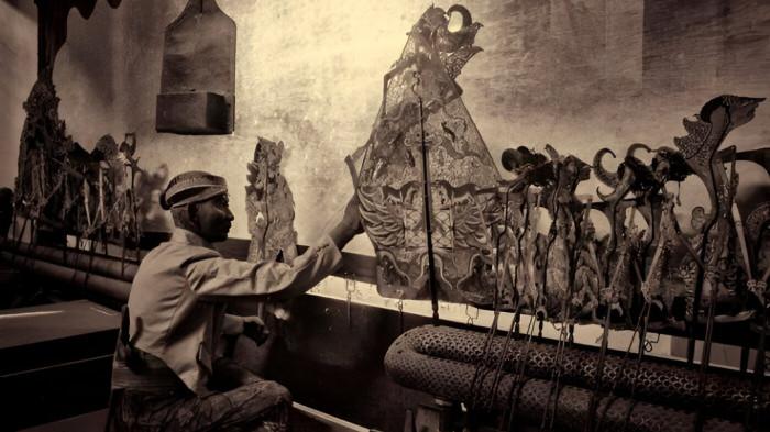 AKSI DALANG- Seorang dalang tengah beraksi memainkan wayang dalam sebuah pertunjukan.