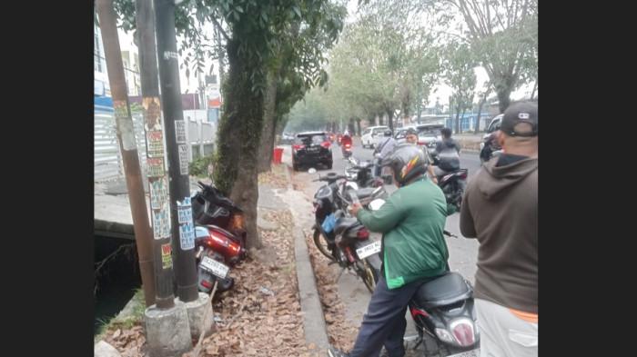LAKA TUNGGAL - Warga melihat kondisi sepeda motor Yamaha N-max yang rusak akibat kecelakaan tunggal di Jalan Ngumban Surbakti, Kecamatan Medan Selayang, Kota Medan, Selasa (3/2/2026). Akibat dari kecelakaan ini, satu orang dinyatakan meninggal dunia dan dua lainnya mengalami luka.