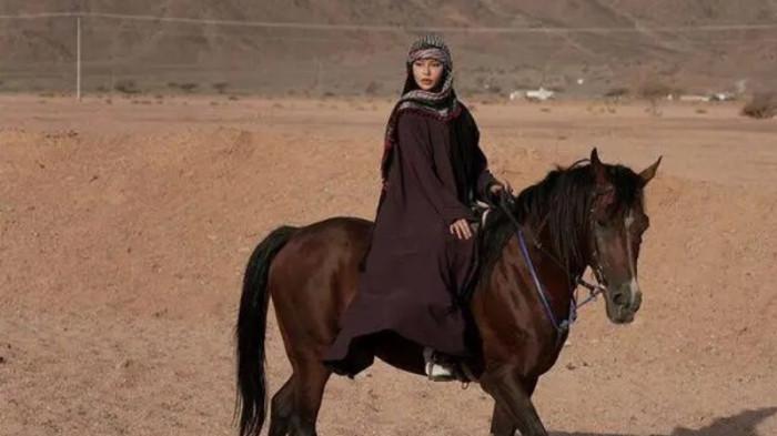 Dara Arafah yang sedang berkuda di gurun pasir Arab.