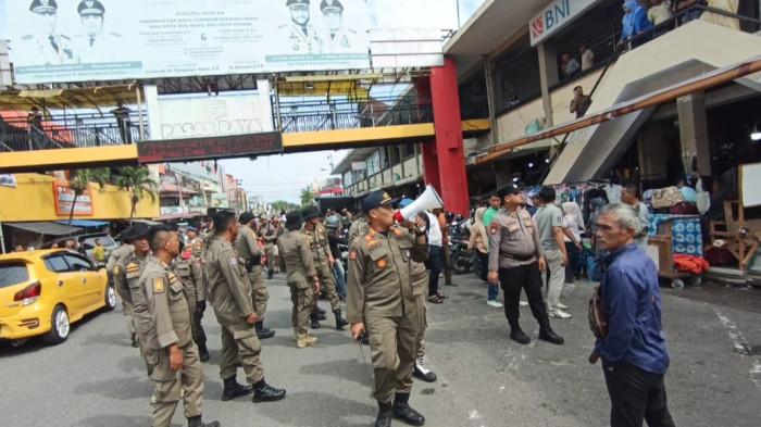 PENERTIBAN PEDAGANG - Tim gabungan Satpol PP, TNI, Polri, dan Dinas Perdagangan melakukan penataan besar-besaran di kawasan Selasar Pasar Raya Padang, Selasa (3/2/2026). Petugas menyisir area pejalan kaki tersebut untuk mengembalikan fungsi fasilitas umum yang selama ini tertutup oleh aktivitas berjualan.