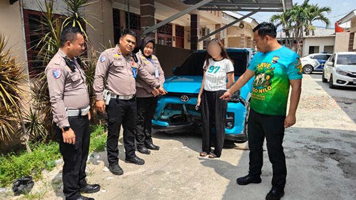 Polisi saat mengamankan tersangka tabrak lari pekerja marka jalan di Pekanbaru, wanita berinisial SH.