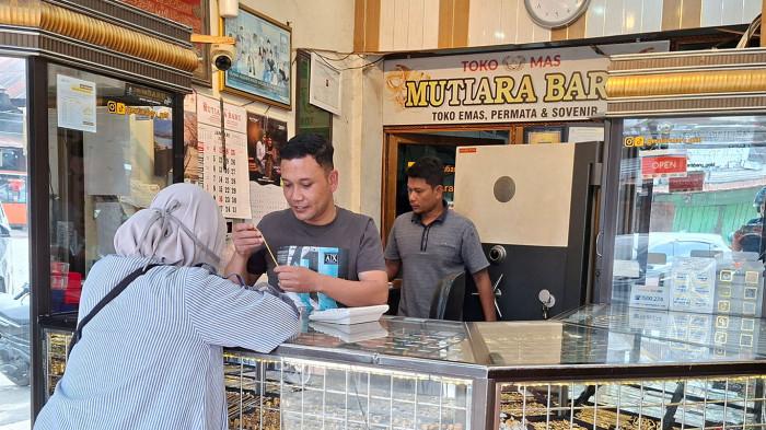 HARGA EMAS HARI INI - Darwis melayani pembelian emas di Toko Emas Mutiara Baru, Simpang Tiga, Bener Meriah, Kamis (22/1/2026). Harga emas di Bener Meriah terpantau mengalami lonjakan signifikan hanya dalam kurun waktu 24 jam pada, Rabu (4/2/2026).