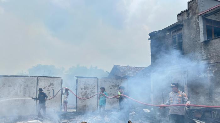 PADAMKAN API - Petugas Damkar, polisi, dan warga bergotong-royong memadamkan api yang membakar rumah Sapin (67) di Dukuh Pohlandak, Desa Sumberagung, Kecamatan Jaken, Kabupaten Pati. Peristiwa tersebut terjadi pada Rabu (4/2/2026) pukul 11.30 WIB. Dok Polsek Jakenan