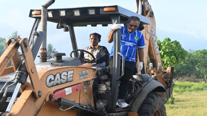 Bupati Manggarai Barat, Edistasius Endi bergantung di atas alat berat, sebuah loder saat kegiatan pembersihan pantai di Labuan Bajo