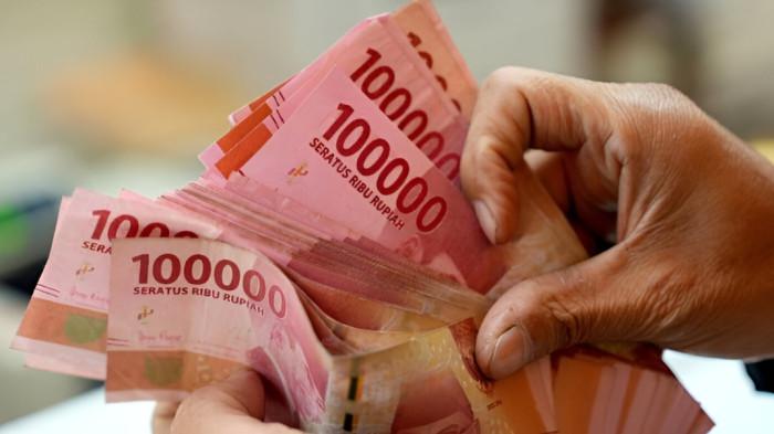 MENGHITUNG RUPIAH- Ilustrasi seseorang tengah menghitung uang pecahan Rp 100 ribu.