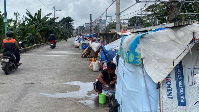 TERPAL - Pemandangan kontras antara jalur kereta api Stasiun Tanah Abang dengan deretan rumah terpal yang berdiri di sepanjang pagar pembatas jalan di Cideng, Jakarta Pusat, Kamis (5/2/2026).