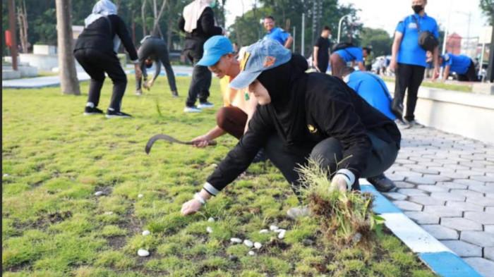 KERJA BAKTI – Sejumlah ASN di lingkungan Pemkab Sidoarjo saat melakukan kerja bakti membersihkan alun-alun Sidoarjo, Jumat (6/2/2026). Selain banyak ditemukan sampah bekas makanan, juga sudah terlihat beberapa kerusakan di sejumlah fasilitas publik yang ada di sana.