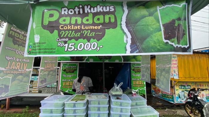 MENGUKUS – Penjual menyiapkan Roti Kukus Pandan Coklat Lumer Mba’Na di lapak sederhana beratapkan payung hijau di Jalan Bukit Kaminting, Palangka Raya, Selasa (10/2/2026).