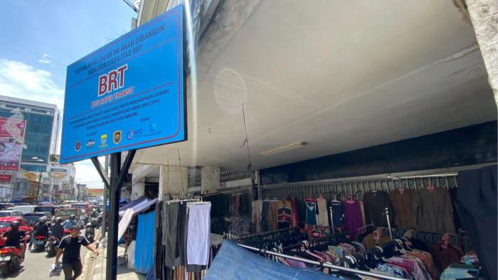 JALUR BRT - Sebuah plang berisi pemberitahuan pembangunan jalur Bus Rapid Transit (BRT) berdiri di kawasan trotoar Pasar Baru, Jalan Otto Iskandar Di Nata, Kota Bandung, Kamis (6/1/2026). Kawasan ini menjadi salah satu jalur BRT yang akan dibangun Januari 2026.
