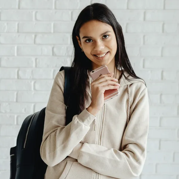 gen z student holding her phone needs a break from tech