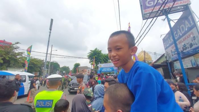 SPPG POLRI - Syahdika (9) antusias melihat Presiden Prabowo Subianto dari dekat di Jalan Palmerah Barat, Jakarta Barat, Jumat (13/2/2026). (Tribunnews.com/Reynas Abdila)