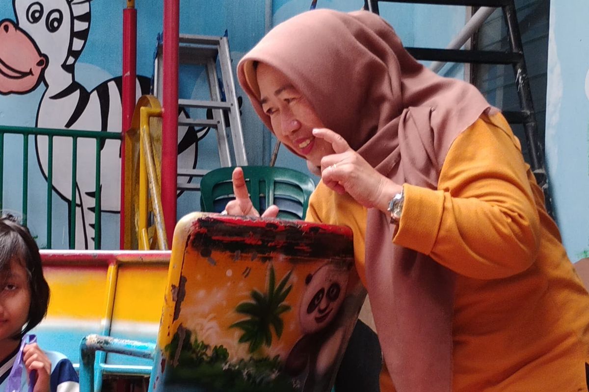 Diah Maria Asih sedang berinteraksi dengan salah satu siswa berkebutuhan khusus, Kamis (12/02/2026).(KOMPAS.com/JACK ROBBY DAMARJATI)