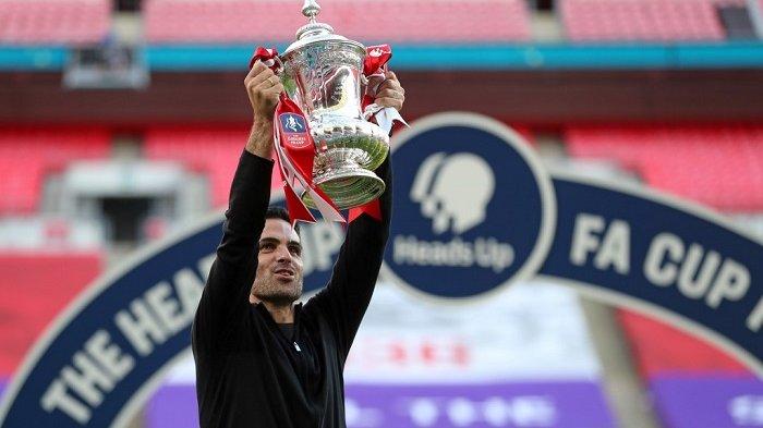 Pelatih kepala Arsenal asal Spanyol Mikel Arteta memegang trofi pemenang saat tim merayakan kemenangan setelah pertandingan final Piala FA Inggris antara Arsenal dan Chelsea di Stadion Wembley di London, pada 1 Agustus 2020. Arsenal memenangkan pertandingan 2-1.Catherine Ivill / POOL / AFP