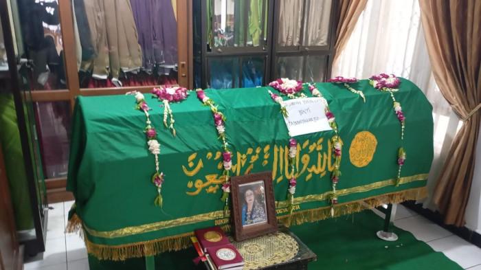 Suasana rumah duka maestro seni tradisi Yogyakarta, Sumisih Yuningsih atau Yu Beruk, di Sanggar Busana Nawangsih, Mantrijeron, Sabtu (14/2/2026). Jenazah disemayamkan dengan balutan kain hijau bertuliskan kaligrafi, dihiasi untaian bunga melati dan mawar. Di depan peti, terpajang foto almarhumah semasa hidup sebagai penghormatan terakhir sebelum dimakamkan di Makam Dongkelan