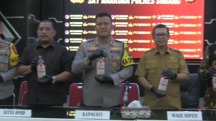 Satresnarkoba Polres Subang menunjukkan barang bukti ratusan botol miras oplosan jenis Vodka BigBoss berwarna merah serta bungkusan minuman energi saat konferensi pers, Sabtu (14/2/2026). Miras oplosan tersebut menewaskan sembilan orang dan menyeret dua tersangka.