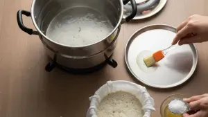Greasing plate for steaming batter.