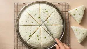 Cutting steamed dhokla into slices.