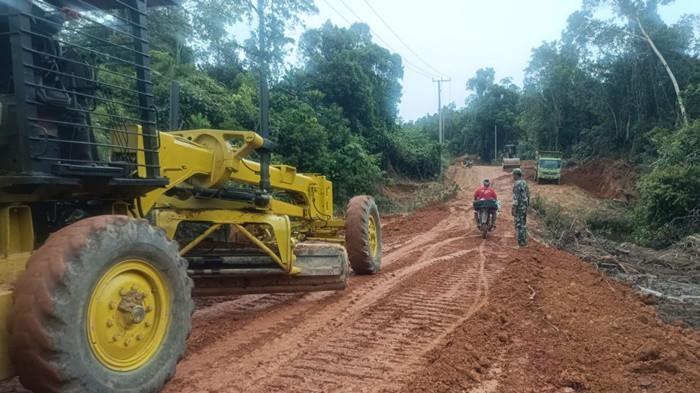 PEMADATAN JALAN -- Sejumlah alat berat grader ketika  melakukan pemadatan badan jalan penghubung menuju area persawahan di Desa Penutuk, Minggu (15/2/2026). Pemadatan dilakukan dalam program TMMD Ke-127, di mana TNI mengawasi langsung proses pengerjaan guna memastikan kualitas konstruksi jalan.