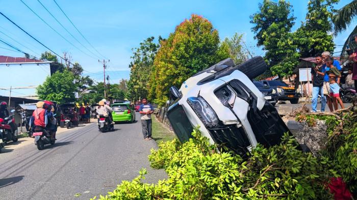 KECELAKAAN MOBIL -- Kondisi mobil Toyota Fortuner yang terjungkal di pinggir jalan. Kecelakaan lalu lintas terjadi di Jalan Pangeran Hidayat, Kota Gorontalo, Minggu (15/2/2026).