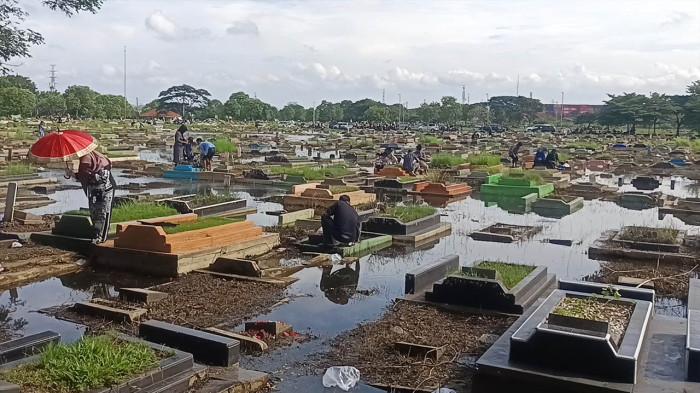 ZIARAH MAKAM TPU SEMPER - Menjelang bulan suci Ramadan, TPU Semper di Cilincing, Jakarta Utara, ramai dikunjungi peziarah, Minggu (15/2/2026). Namun, kondisi sejumlah makam yang masih tergenang banjir membuat kenyamanan peziarah terganggu. (TRIBUNJAKARTA.COM/GERALD LEONARDO AGUSTINO).