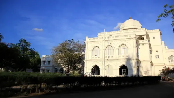 White heritage building with a domed roof under a clear blue sky.