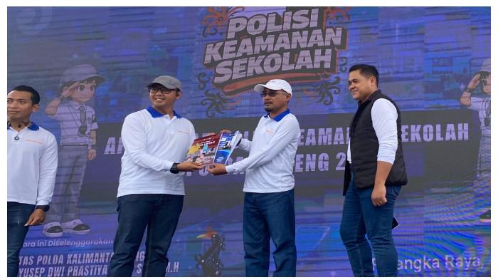 MENERIMA - Plt Kepala Dinas Pendidikan Kota Palangka Raya, Jayani (Topi Putih), menerima buku materi PKS dalam kegiatan Polisi Keamanan Sekolah di Bundaran Besar Palangka Raya, Minggu (15/2/2026).