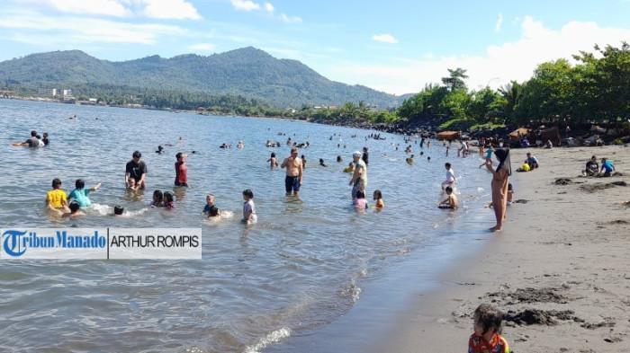 WISATA PANTAI - Pantai Karangria di Kelurahan Karangria, Kecamatan Tuminting, Kota Manado, Provinsi Sulawesi Utara (Sulut), dipadati wisatawan, Minggu (7/9/2025). Selain bersantai, warga datang untuk tujuan pengobatan.