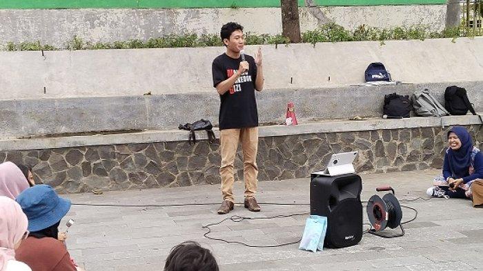 RENTETAN TEROR: Ketua BEM UGM, Tiyo Ardianto menyampaikan orasi dalam aksi Karaoke WNI Mumet yang digelar oleh Komunitas Suara Ibu Indonesia di Yogyakarta di Bundaran UGM, Jumat (13/2/2026). Tiyo mendapat rentetan teror setelah pengiriman surat Ironi Tanah Air ke UNICEF.