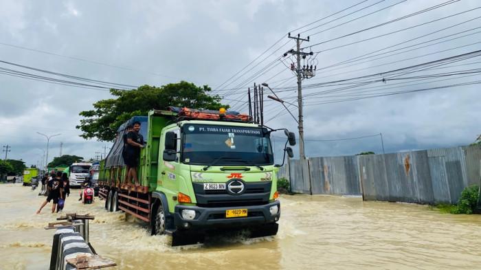 BANJIR PANTURA TEGAL - Jalan Pantura Kabupaten Tegal-Pemalang, Desa Kedungkelor, Kecamatan Warureja tergenang banjir, Senin (16/2/2026). Ketinggian air mencapai sekira 30 sentimeter dari luapan Sungai Rambut.
