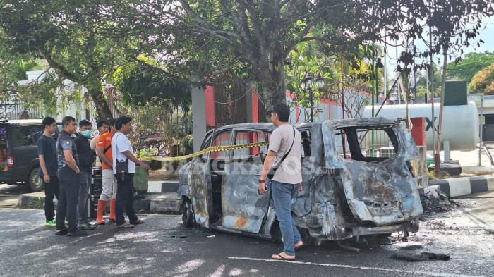 MOBIL TERBAKAR -- Petugas Kepolisian Polresta Pangkalpinang, ketika memasang garis police line terhadap kendaraan hangus terkabar di depan SPBU Kejora, Desa Beluluk, Kecamatan Pangkalan Baru, Kabupaten Bateng, Senin (16/2/2026).