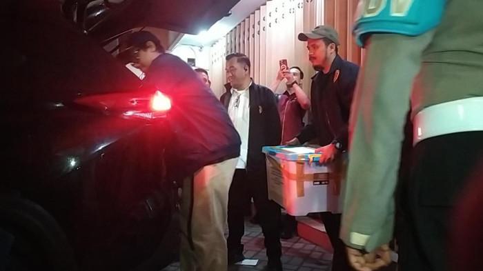 PENGGELEDAHAN - Penyidik Dittipideksus Bareskrim Polri keluar membawa empat kotak barang bukti dari rumah dua lantai di Jalan Tampomas No 3, Sawahan, Surabaya, Kamis (19/2/2026). Barang bukti yang disita berisi dokumen, surat, uang, transaksi elektronik, dan belasan kilogram batangan emas.