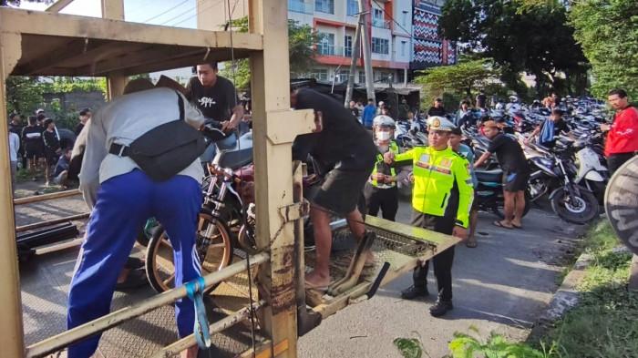 BALAP LIAR - Ratusan unit sepeda motor disita dan diangkut menggunakan truk, hasil grebekan di area balap liar di Jl Arteri Porong, Kabupaten Sidoarjo, Jawa Timur, Jumat (20/2/2026).