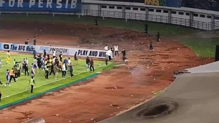 AKSI OKNUM SUPORTER - Pemain, pelatih, hingga staf Persib Bandung mengadang oknum suporter dari tribun bagian selatan yang merangsek masuk ke lapangan setelah laga melawan Ratchaburi FC di Stadion Gelora Bandung Lautan Api (GBLA), Rabu (18/2/2026) malam dalam leg kedua babak 16 besar AFC Champions League Two (ACL 2) 2025/2026.