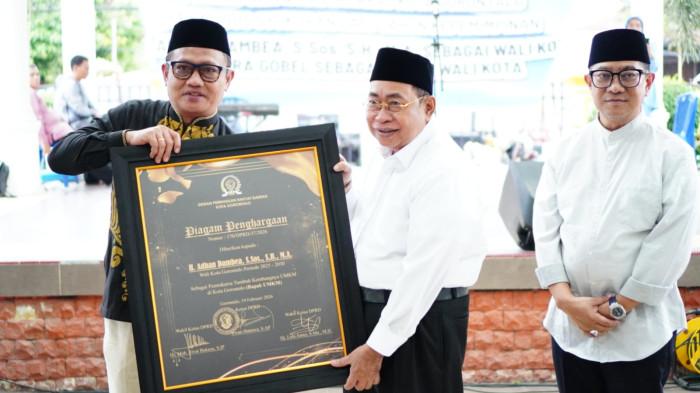 PIAGAM -- Wali Kota Gorontalo, Adhan Dambea saat menerima piagam penghargaan dari Ketua DPRD Kota Gorontalo sebagai 